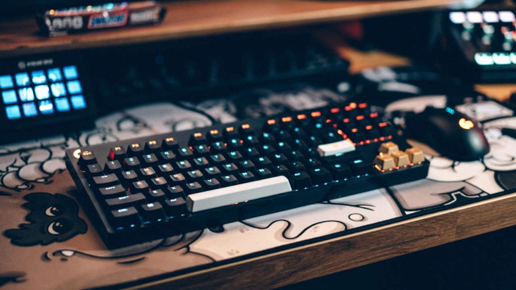 Teclado mecânico e mouse gamer em cima de mesa