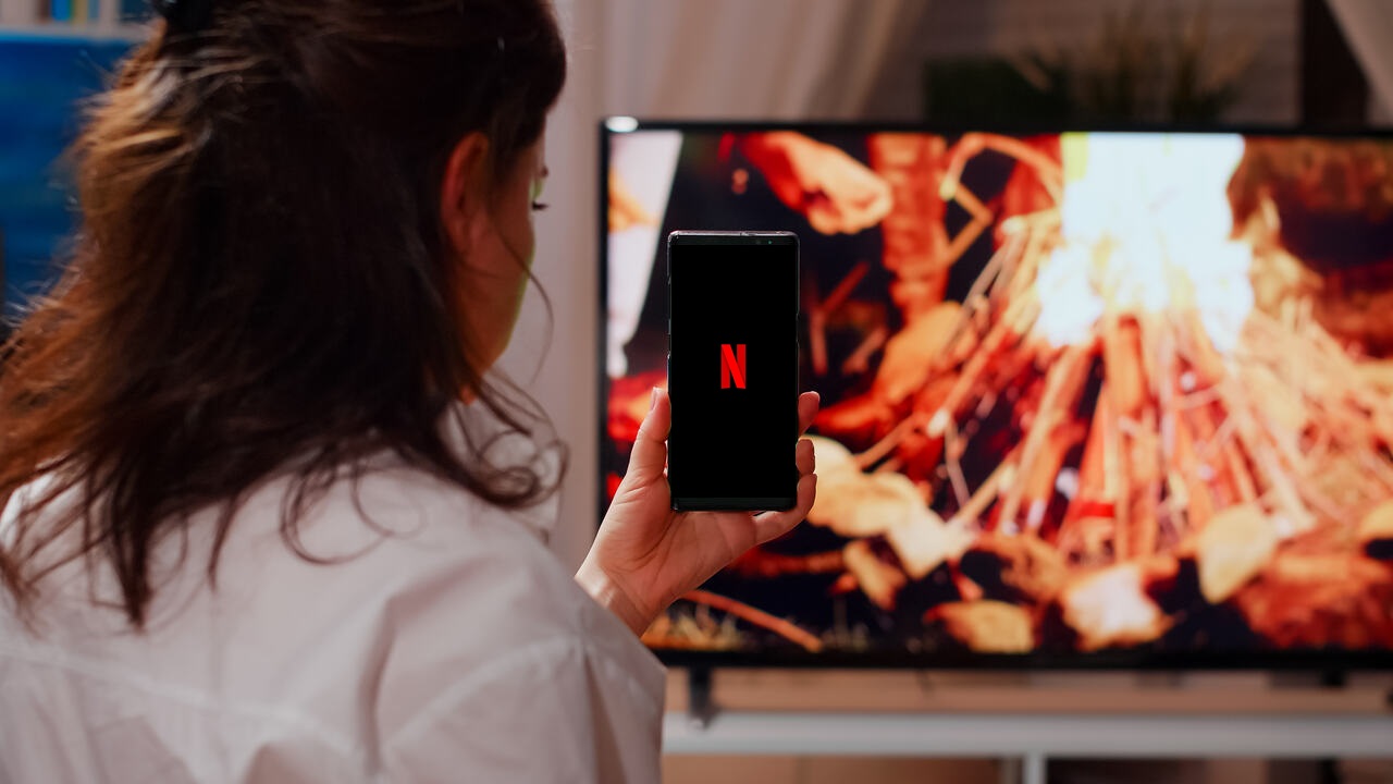 Mulher abre Netflix no celular para espelhar na TV 