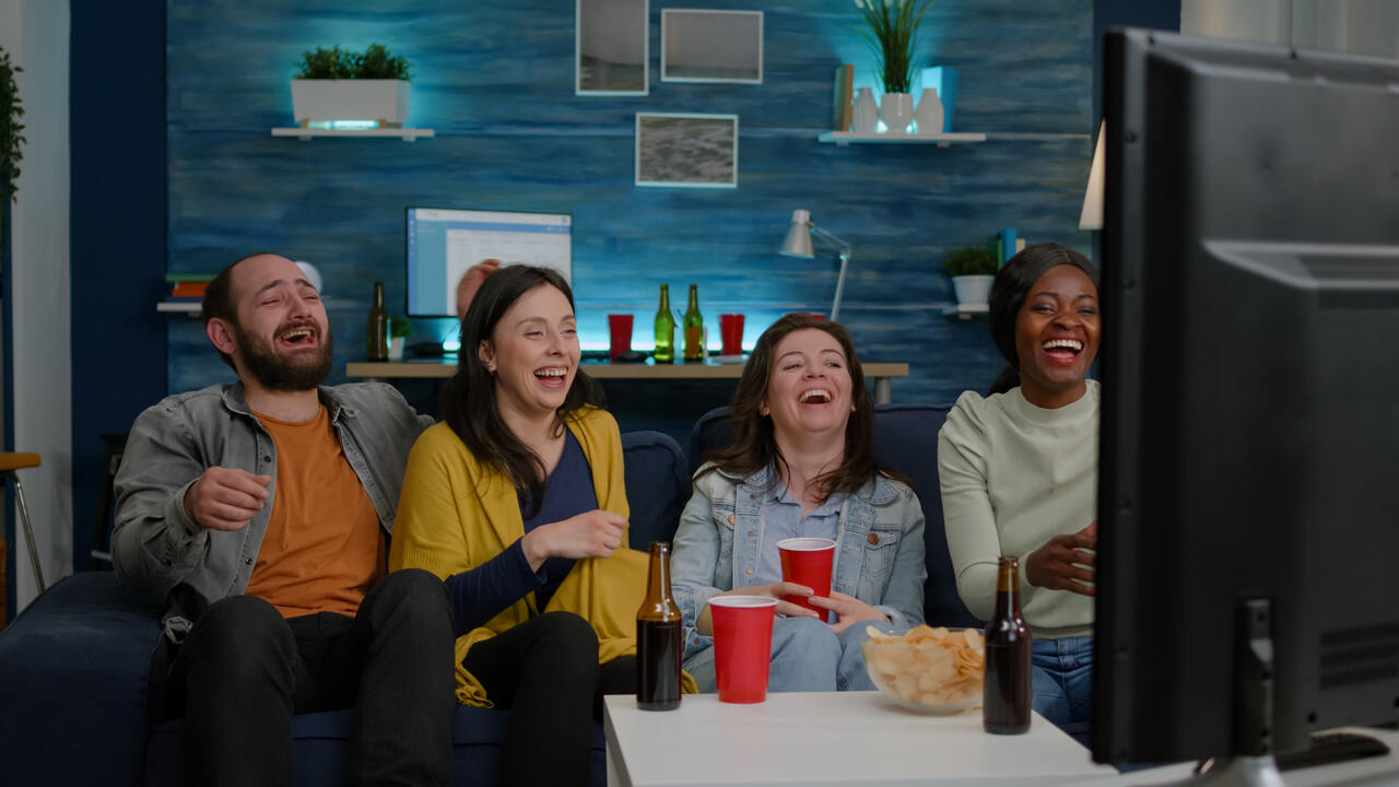 Grupo de amigos se divertem assistindo TV 