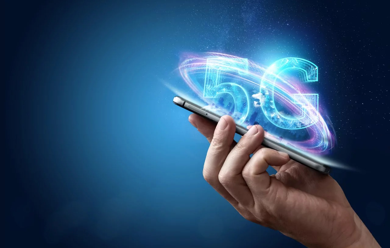 Pessoa segurando um celular, com imagem 5G sendo projetada da tela