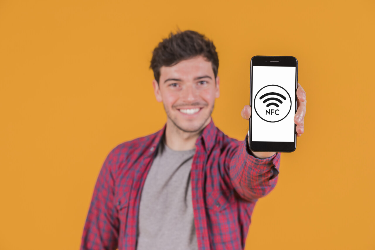 Jovem mostra tela do celular com tecnologia NFC em ação 