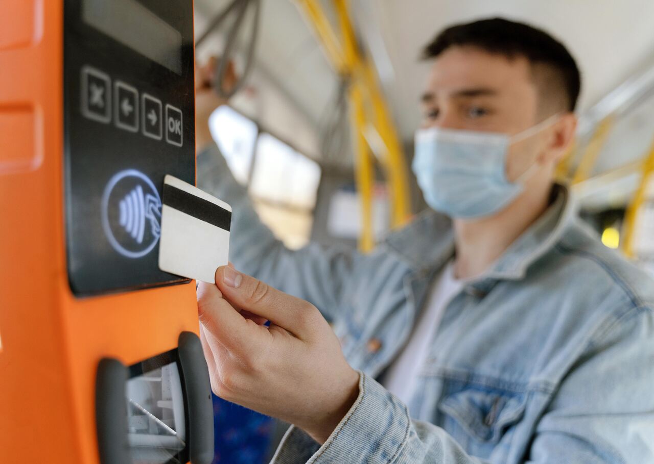 Jovem paga passagem do transporte público usando cartão com NFC 