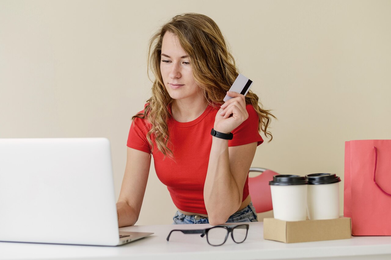 Mulher faz compras online com expressão apreensiva 