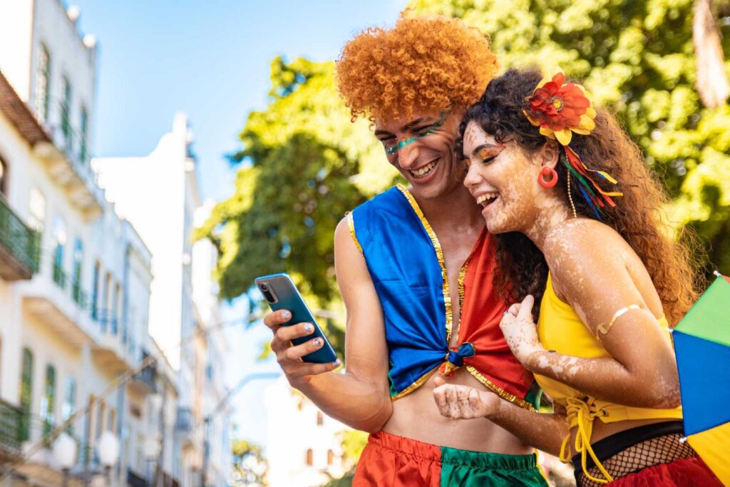 Foliões com celular em Carnaval